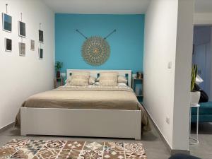 een slaapkamer met een bed met een blauwe muur bij Stampixeddu in Cagliari