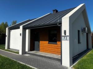 a small house with an open garage at Leśna Polana Domki in Okuninka +62 photos