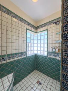 a bathroom with green tiled walls and a window at El Ojo del Mar - Las Conchas in Puerto Peñasco +58 photos