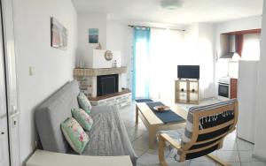 a living room with a couch and a table at Roses RT apartments Skioni I in Nea Skioni