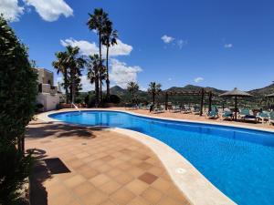 a swimming pool with palm trees and mountains in the background at Casa de Ensueño - exklusive Villa mit 3 Schlafzimmern, 3 Bädern, 4 Terrassen mit Panoramaausblick in Atamaría