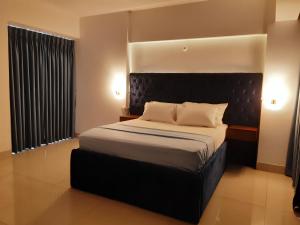 Un dormitorio con una cama grande con cabecero negro. en SM Comfort Stay, en Dhaka