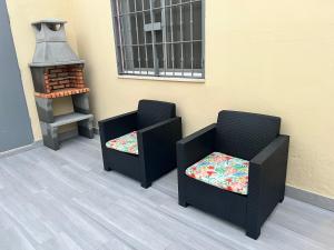 Dos sillas sentadas junto a una pared con una estufa. en Selva House Sevilla, en Coria del Río 25 fotos más