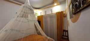 a bedroom with a bed with a net on the ceiling at Umah de Madya The Room & Panoramic Rooftop Munduk in Munduk