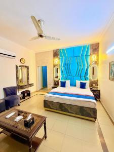 a bedroom with a king sized bed and a living room at New Pakeeza Hotel in Lahore