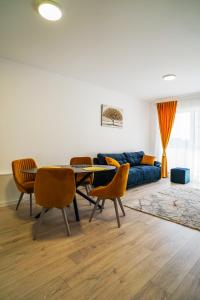 布拉索夫Mirandis Apartments - Modern Stays with Free Parking near Coresi Mall的带沙发、桌子和椅子的客厅