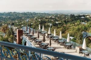 a balcony with tables and umbrellas on a mountain at Roots Resort in Kobuleti