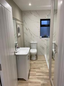 a white bathroom with a toilet and a sink at TheWeeHouseOnTheHill in Kilrea +45 photos