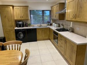 a kitchen with wooden cabinets and a stove top oven at TheWeeHouseOnTheHill in Kilrea
