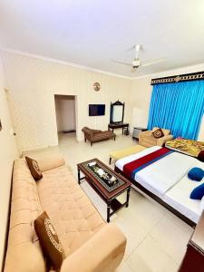 ein großes Wohnzimmer mit einem Bett und einer Couch in der Unterkunft New Pakeeza Hotel in Lahore