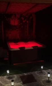 un lit rouge dans une pièce sombre avec deux bougies dans l'établissement location insolite nuit étoilée, à Bettaincourt-sur-Rognon