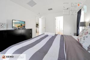 une chambre avec un grand lit avec une télévision à écran plat dans l'établissement Private Pool Oasis with King Bed, à Kissimmee