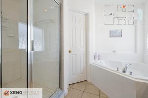 une salle de bain blanche avec une baignoire et une douche dans l'établissement Private Pool Oasis with King Bed, à Kissimmee 50 autres photos