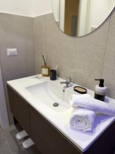 La salle de bains est pourvue d'un lavabo, d'une serviette et d'un miroir. dans l'établissement VK Rooms, à Bari