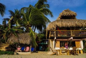 a woman standing in front of a hut on the beach at Canto de Caracola in Rincón