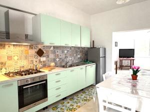 a kitchen with white cabinets and a stainless steel refrigerator at Casa di Mael in Maratea