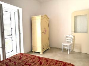 a bedroom with a cabinet and a chair next to a window at Casa di Mael in Maratea