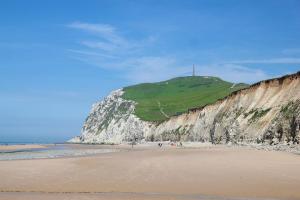 a beach with a cliff and a green hill at La baraque bleriot beach in Sangatte