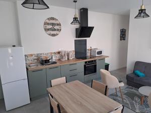 a kitchen and living room with a table and a couch at La baraque bleriot beach in Sangatte