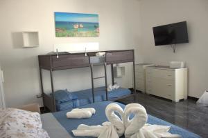 een slaapkamer met een stapelbed met witte handdoeken bij D&C House in Galatone