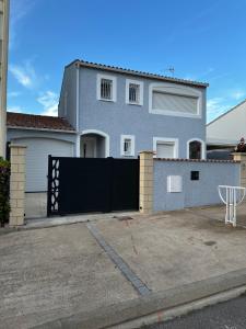 una casa con un cancello nero e una recinzione di Villa la Nautilia a Cap d'Agde