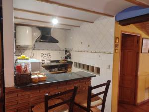 eine Küche mit Tisch und Arbeitsplatte in der Unterkunft Casa Valentina y La buhardilla in Salvacañete + 10 Fotos