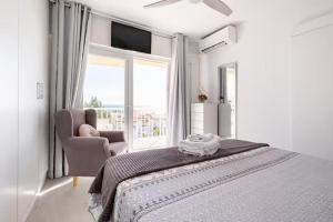 a white bedroom with a bed and a window at RentitSpain - Nerja - Apartamentos Vistas Únicas al Mar Mediterráneo in Nerja +31 photos