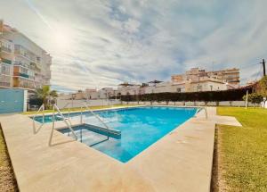a large blue swimming pool with buildings in the background at RentitSpain - Nerja - Apartamentos Vistas Únicas al Mar Mediterráneo in Nerja