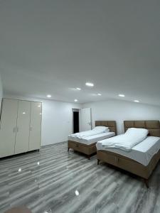two beds in a large room with wooden floors at VILA Natura Sarajevo in Gladno Polje