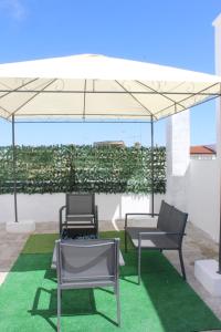 een paviljoen met twee stoelen en een tafel eronder bij D&C House in Galatone