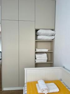 Un armario con gabinetes blancos y toallas blancas. en Apartman Pablo, en Kotor