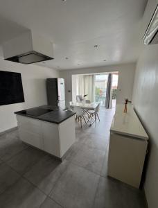 a kitchen with a counter and a table in it at Petit Nid Pieds dans l'eau in Sausset-les-Pins