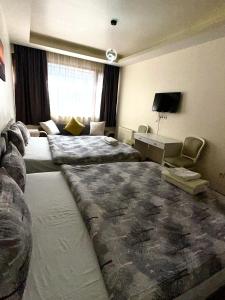 a hotel room with two beds and a desk at Center Hotel Two in Istanbul