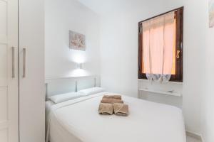 a white bedroom with a bed with two towels on it at Casa Mimose, 200m to beach in Pula