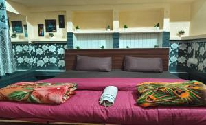 - un grand lit avec une couverture et des oreillers roses dans l'établissement The Street homestay, à Agra