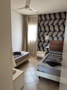 a bedroom with two beds and a window at Tropical Casa Castanha in Santa Maria