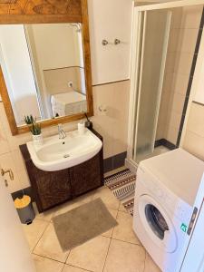 a bathroom with a washing machine and a sink at Tropical Casa Castanha in Santa Maria