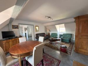 Gîte Jeanne familial - calme - parking في Ebersheim: غرفة معيشة مع طاولة وكراسي خشبية