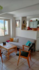 een woonkamer met een bank en een tafel bij La retapée in Quinson