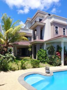 a house with a swimming pool in front of it at Villa Azalea in Grand Baie