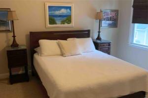 a bedroom with a bed with two night stands and a window at 3 Bedroom Cozy Cottage with fenced in backyard and hot tub 4 miles to the beach in Wilmington