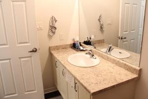 a bathroom with a sink and a mirror at Sandell Place in Oshawa