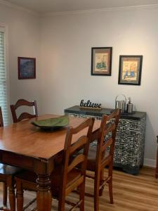 a dining room table with chairs and a table with a kitchen at 3 Bedroom Cozy Cottage with fenced in backyard and hot tub 4 miles to the beach in Wilmington