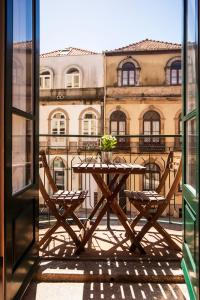 einen Holztisch und Stühle auf dem Balkon in der Unterkunft Lighthouse Apartment in Porto