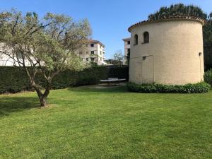 un edificio con un árbol y un banco en un campo en Apartment S'agaró-Costa Brava, en S'Agaró