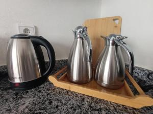 布兹尼盖Appartement Golden Beach-Dahomey的木托盘上的两个银质和黑色茶壶