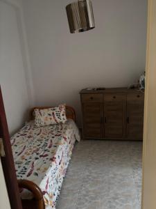 a small bedroom with a bed and a dresser at Haus Rosi in Rhodes Town