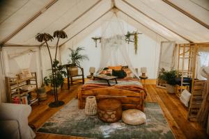 a bedroom with a bed in a tent at Kaluna Glamp Jungle in Swaderki