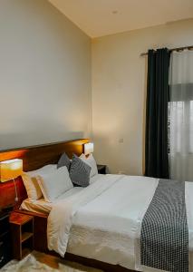 a bedroom with a large white bed and a window at Casa Residence Mbarara in Mbarara +48 photos