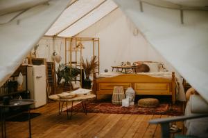 a bedroom with a bed in a tent at Kaluna Glamp Jungle in Swaderki